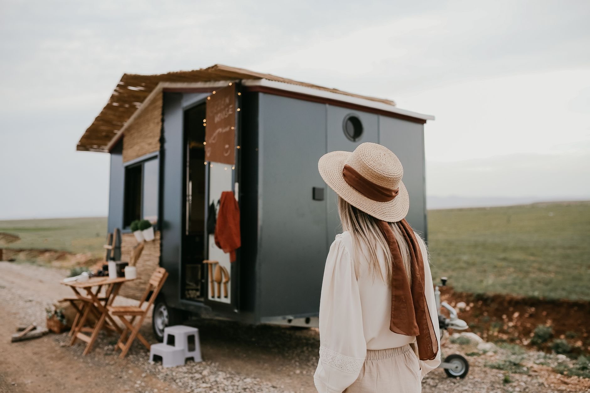 A completed tiny house on wheels in a rural landscape